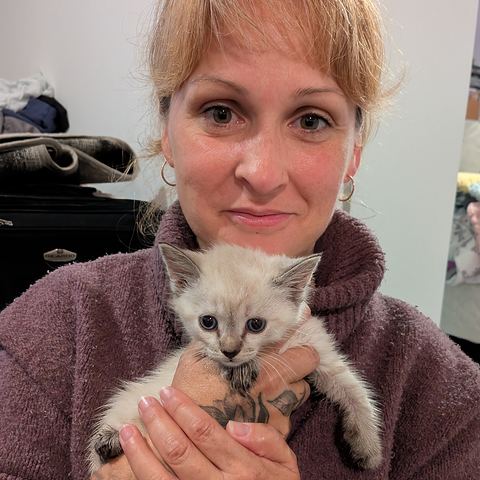 Stéphanie Portelance smiles while holding a small white kitten.